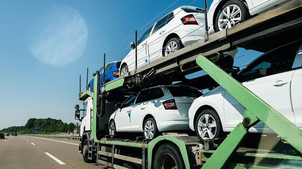 Auto transport truck carrying multiple cars on a highway.