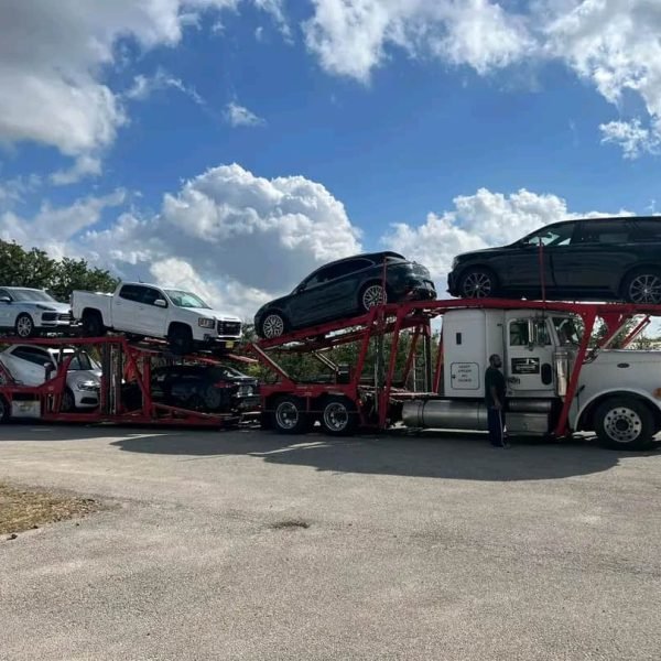 Auto transport truck carrying multiple vehicles on a sunny day.
