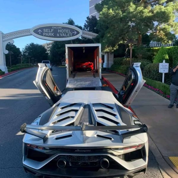 High-end sports car being loaded into a transport truck.