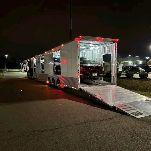 Car shipping truck at night with cars loaded for delivery.