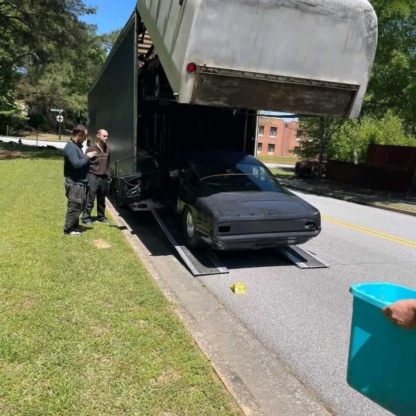 Oversized vehicle being transported on a car carrier truck.