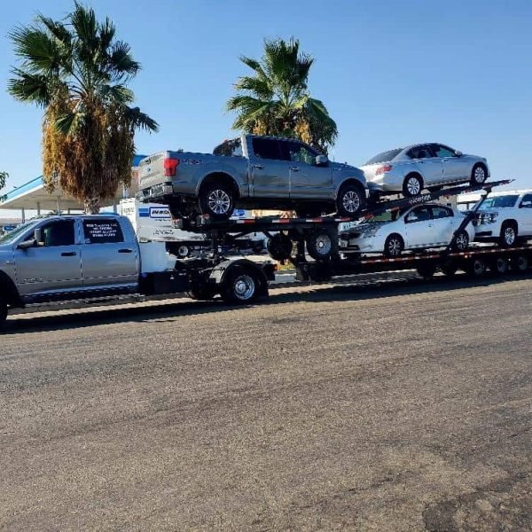 Multiple cars loaded on a transport truck for auto shipping.