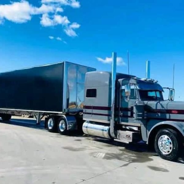 Semi truck with black trailer for auto transport services.